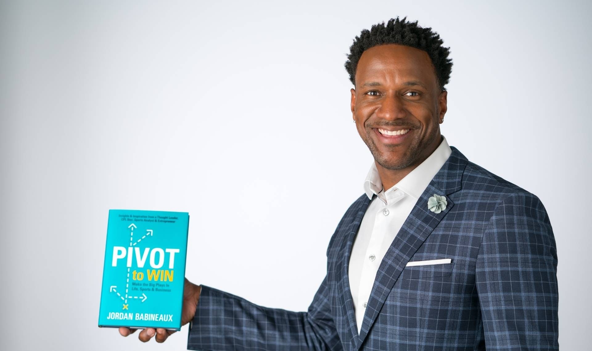 Jordan Babineaux holding his book Pivot to Win